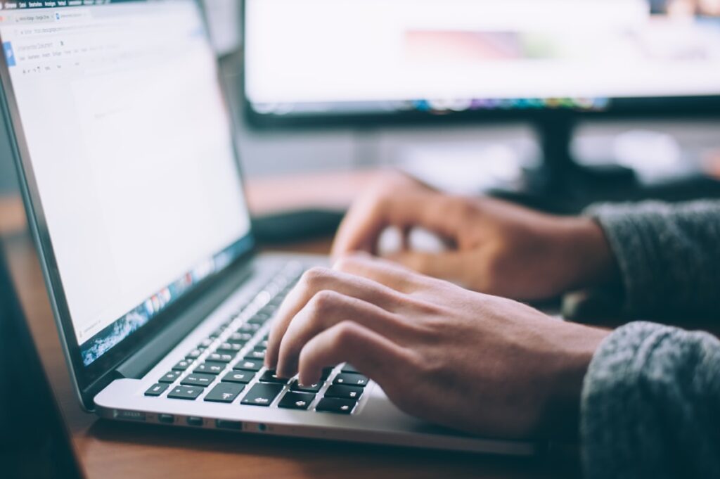 Mains qui rédigent un email de prospection sur un ordinateur portable, écran de messagerie professionnelle ouvert