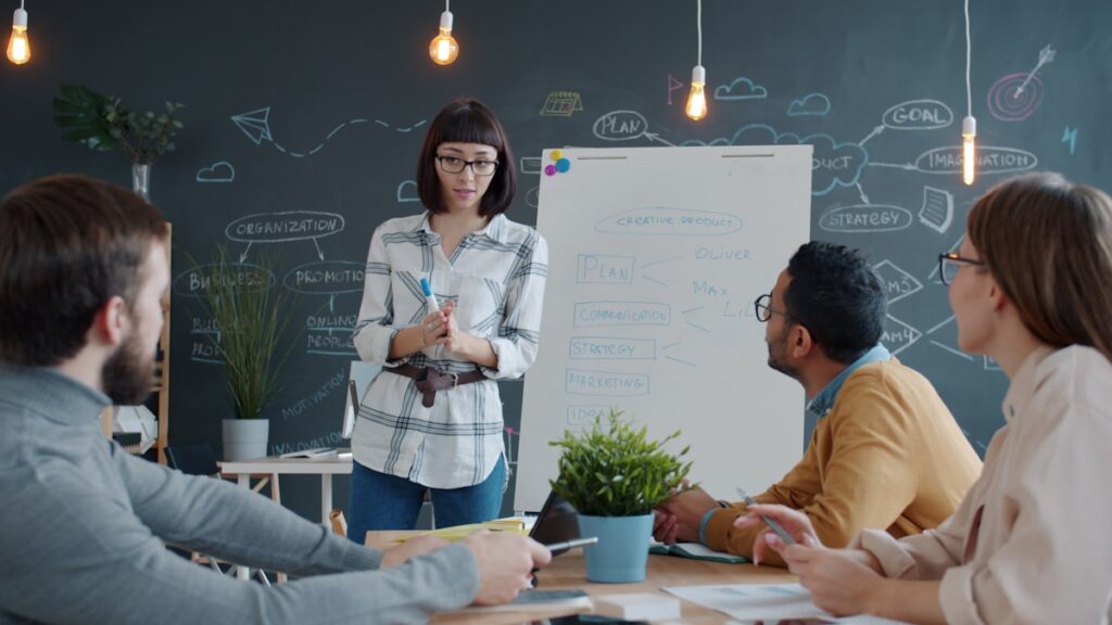 quipe de PME B2B en réunion stratégique autour d'un paperboard, discussion sur la structuration de la prospection commerciale