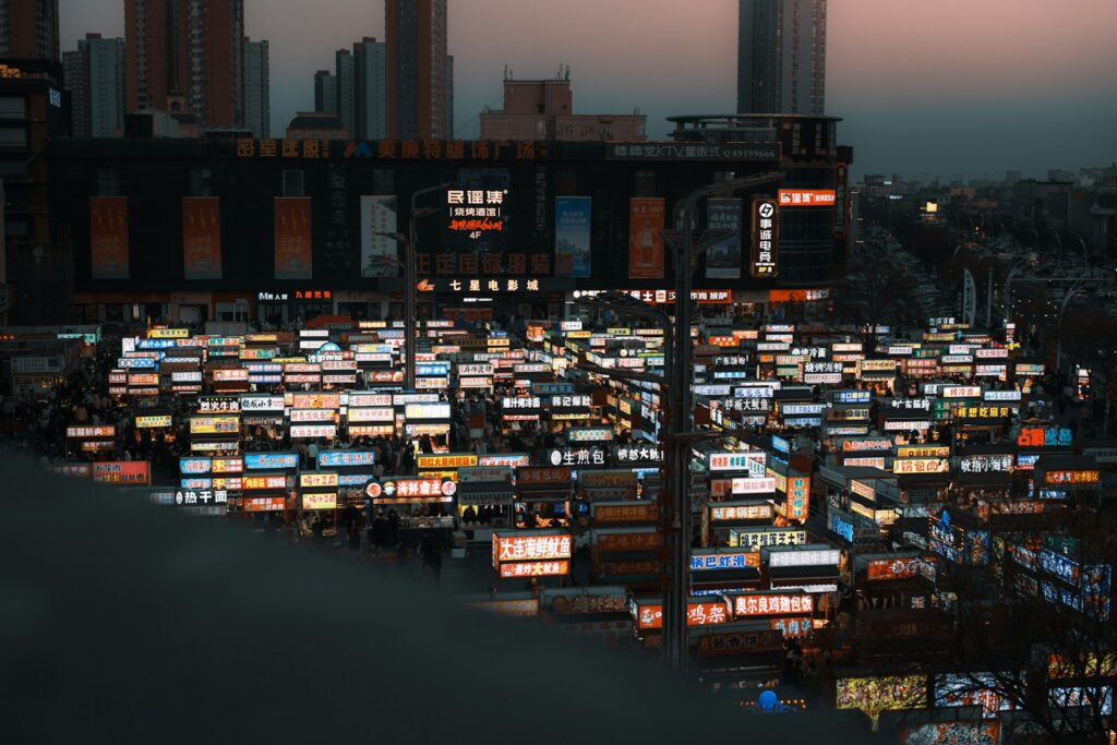 Vue panoramique d'une ville la nuit saturée d'enseignes commerciales lumineuses illustrant un marché B2B encombré