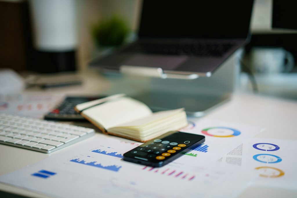 Tableau de bord commercial PME avec graphiques imprimés, calculatrice, carnet et ordinateur portable
