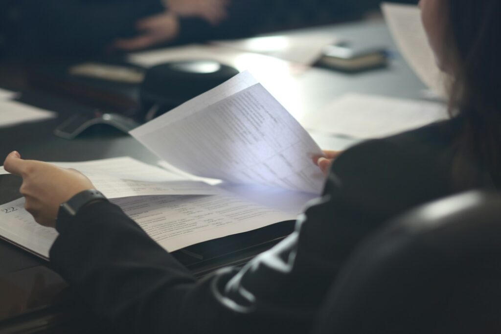 Dirigeante de PME B2B examinant des documents contractuels d'un prestataire de prospection commerciale en salle de réunion
