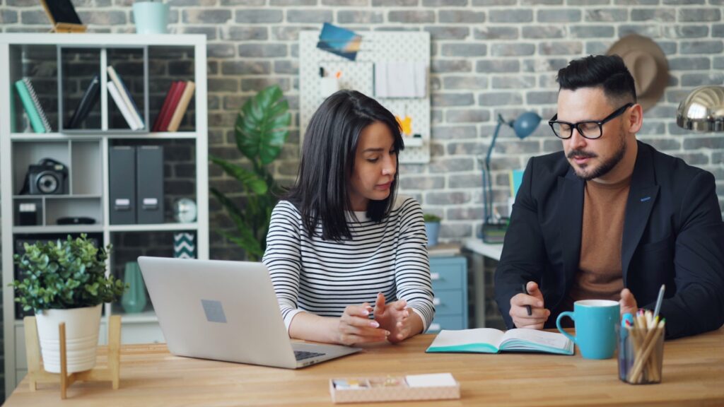 Deux collaborateurs d'une PME structurent leur plan de prospection commerciale devant un ordinateur et un carnet ouvert