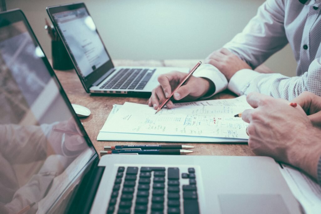 Deux dirigeants de PME analysent un plan de prospection commerciale sur papier et sur ordinateur