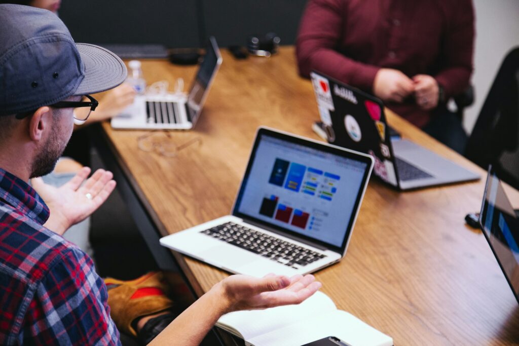 Équipe d'une PME tech réunie autour d'un ordinateur affichant l'interface d'un logiciel