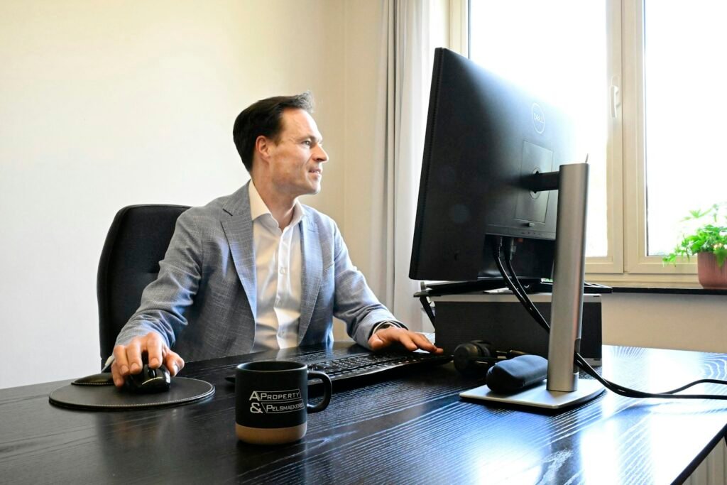 Dirigeant de PME concentré devant l'écran de son ordinateur dans un bureau lumineux