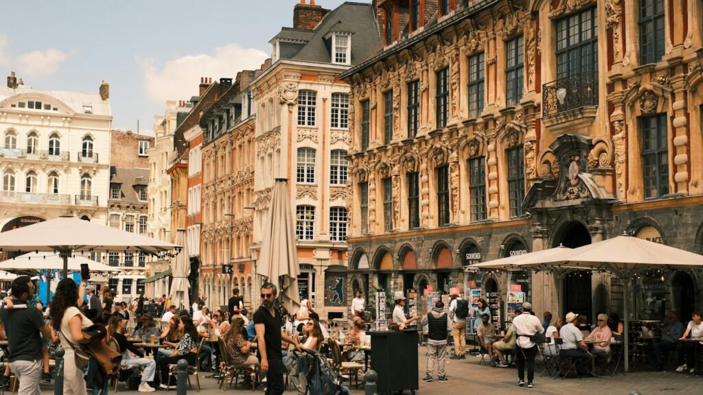 Terrasses de la Grand Place de Lille où des groupes échangent autour d'une table en fin de journée
